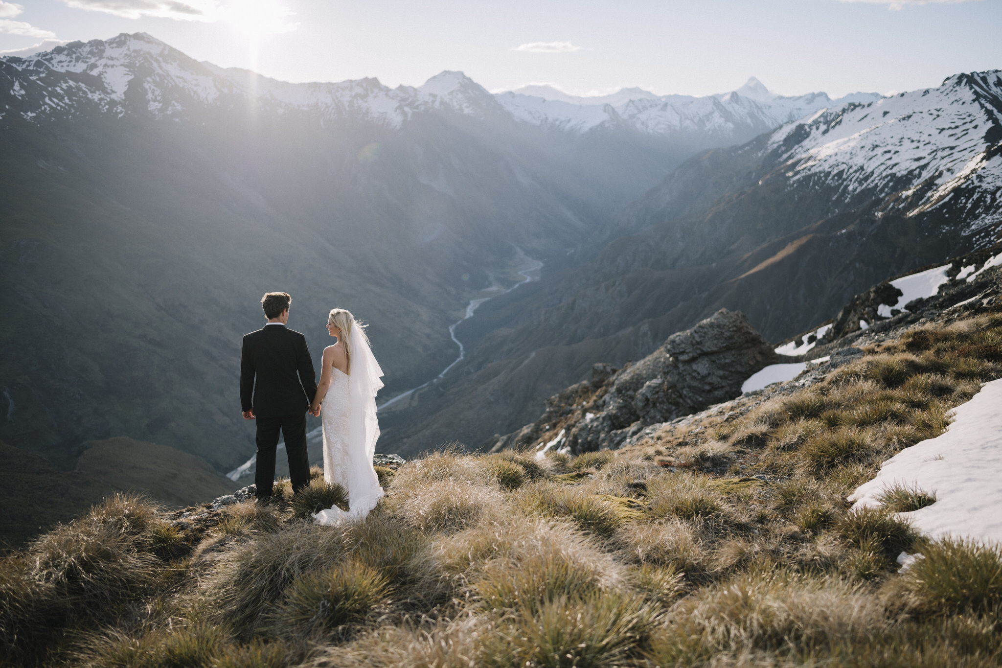 Jenny and Jason standing with an epic view at Twin Peaks, Wanaka on their elopement