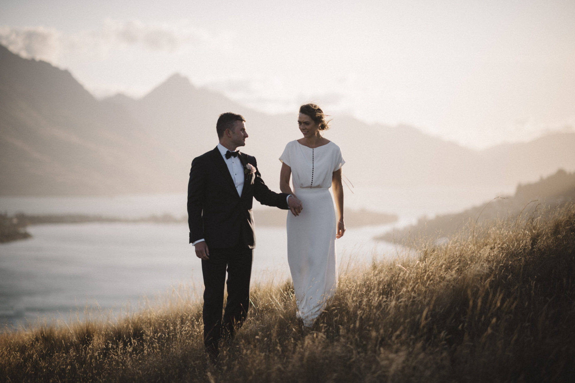 Emily & Wyatt at High Country NZ wedding venue, Queentown walking together at sunset